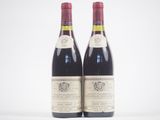 deux bouteilles de vin rouge posées l'une à côté de l'autre sur une surface blanche