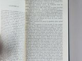 a person holding a book open on a table