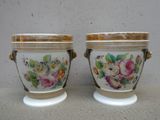 deux vases avec des fleurs peintes dessus, posés sur une table