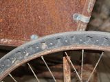 a rusted bike wheel with holes in the tire