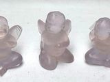 trois figurines en plastique représentant des anges assis sur une surface blanche