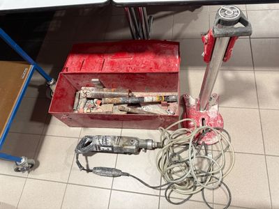 a red tool box sitting on the floor next to a table