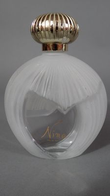 une image représentant un flacon de parfum avec un bouchon doré