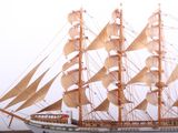 a model of a sailboat on the water near a lighthouse
