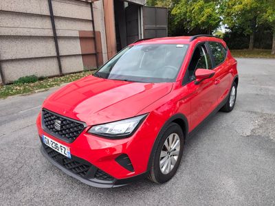une voiture rouge garée sur le bord de la route, devant un immeuble