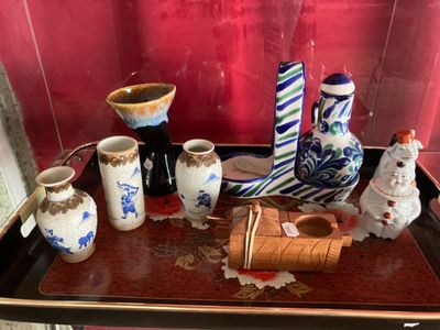 un plateau sur lequel sont disposés de nombreux vases de styles variés