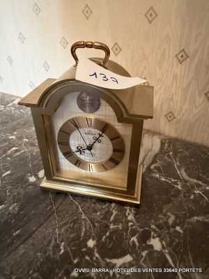 a small clock sitting on a marble counter top