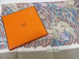 an orange box sitting on top of a bed next to a pillow