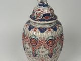 a large vase with a lid on a white surface
