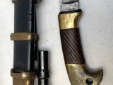 un gros plan d'un couteau posé sur une surface blanche, à côté d'une pipe