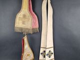 three pieces of cloth hanging from hooks on a wall