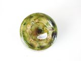 a green vase with a tag on it sitting on a white surface