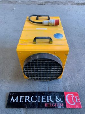 a yellow heater sitting on the ground next to a sign