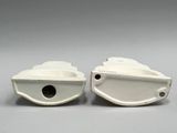 pair of white ceramic boat shaped vases on a gray background
