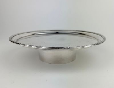 a close up of a silver plate on a white surface