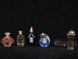 several bottles of perfume are lined up on a black surface