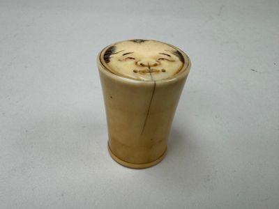 un gros plan d'un petit vase sur lequel est représenté un visage