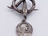 an image of a silver snake and a coin on a white surface
