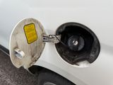 a white car with a gas pump attached to it ' s side
