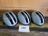trois casques posés sur une table, à côté d'un panneau