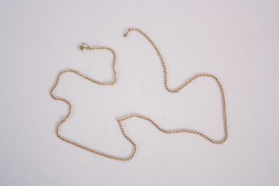 collier plaqué or avec un pendentif en forme de colombe sur fond blanc