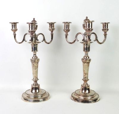 paire de candélabres plaqués argent avec des bougeoirs sur pied