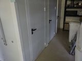 une pièce avec plusieurs portes et une poubelle à l'intérieur