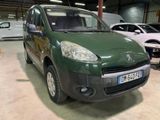 une petite camionnette verte garée dans un garage avec d'autres voitures