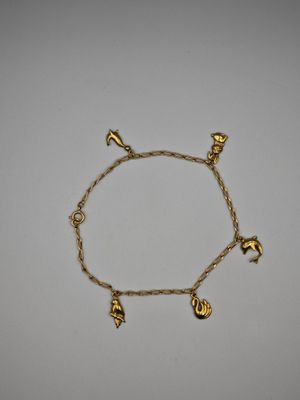 un bracelet en or avec des breloques sur une chaîne