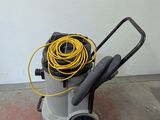 a vacuum with a hose on the floor next to a wall
