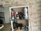 une étagère en verre sur laquelle sont posés de nombreux produits capillaires