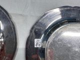 two silver plates on a table with a white table cloth