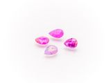 a group of three pink and white crystals on a white surface