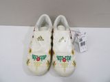 pair of white shoes with colorful flowers on them sitting on a white surface