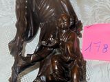 a bronze statue of a man with a dog on a bed