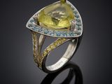 a close up of a ring with a yellow topazr and blue topazr