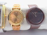 three different watches are sitting on top of each other on a white surface