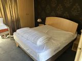 a bed with a white comforter on it in a bedroom