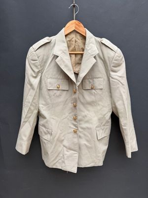 une vieille veste accrochée au mur avec un cintre en bois