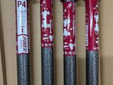 three red and silver baseball bats sitting on top of a cardboard box