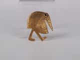 a close up of a gold plated bird on a white surface