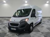 la camionnette blanche est garée dans une grande pièce au sol en damier