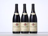 three bottles of wine are lined up on a table