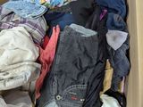 a cardboard box filled with clothes and clothes on the floor