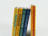 trois livres empilés sur une surface blanche