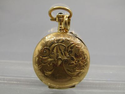 a gold pocket watch with a chain on a table