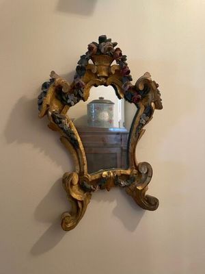 un miroir accroché au mur à côté d'une horloge
