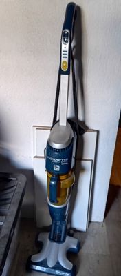 un aspirateur posé par terre à côté d'une cuisinière