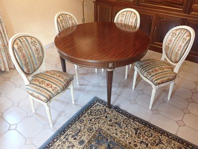 une table avec quatre chaises et un tapis au sol