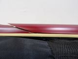 a red and yellow pen sitting on top of a black bag